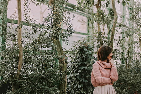 woman standing near green leaf plants thumbnail