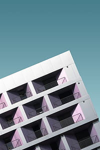 grey concrete building under blue sky thumbnail