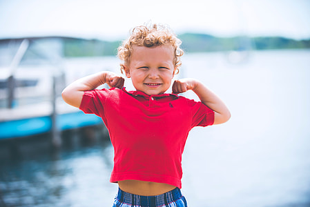 boy wearing maroon polo shirt near body of water during daytime thumbnail