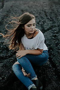 woman sitting on black soil during daytime thumbnail
