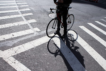 man riding a bike standing in pedestrian lane thumbnail