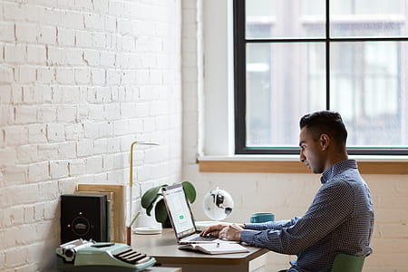 Man Sitting on Green Chair While Using Laptop thumbnail