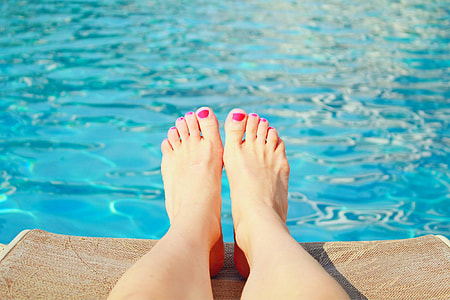 person with pink pedicure on pool side during daytime thumbnail