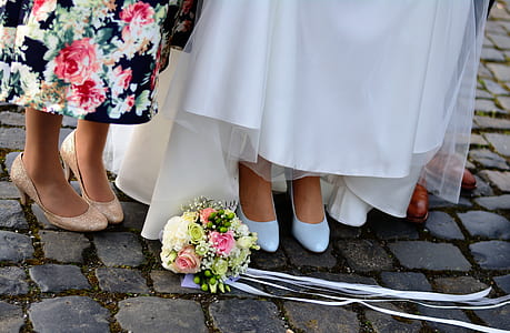 flower bouquet on gray concrete pavement near woman's feet thumbnail
