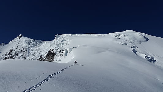 person walking on snow capped mountain thumbnail
