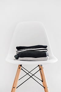 folded clothes on white chair thumbnail
