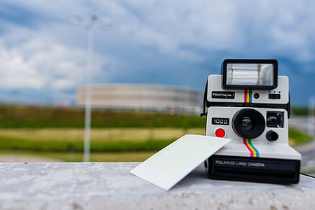white Polaroid land camera beside photo at daytime thumbnail