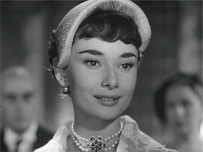 grey scaled photo of woman wearing hat and beaded necklace thumbnail