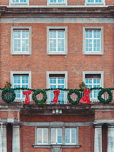 red and green wreath and bow accent hanged on building terrace thumbnail
