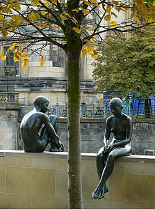 man and woman statue on beige concrete fence thumbnail