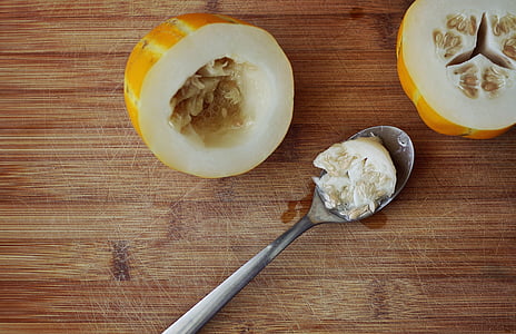 melon seeds on spoon between sliced melon thumbnail