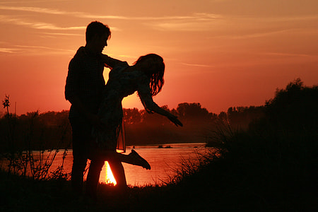 silhouette of man and woman near body of water during daytime thumbnail