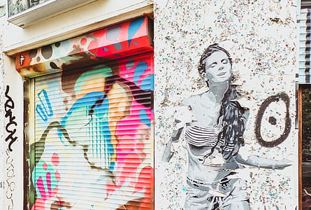 Stencil Art of Woman on Wall Near Door Shutter With Graffiti thumbnail