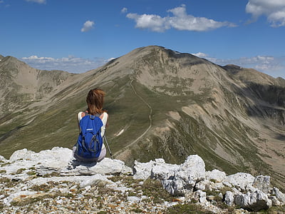 person sitting on rock in front on mountain thumbnail