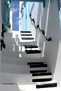 white and black concrete stairs between wall with sunlight passing through thumbnail