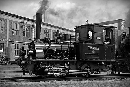 grayscale photography of train near building thumbnail