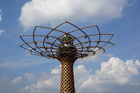 brown metal tower under white cloud blue skies thumbnail
