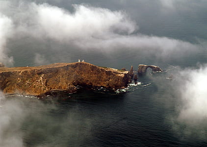 brown rock formation near body of water thumbnail