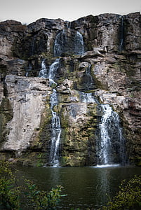 waterfalls on rock formation at daytime thumbnail