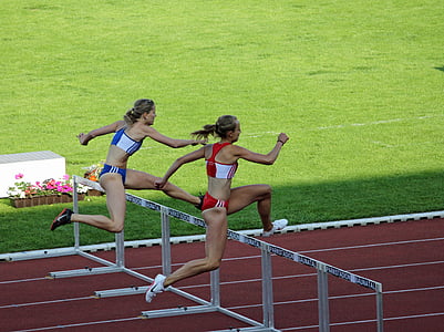 woman jumping on hurdle during daytime thumbnail