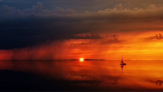silhouette of sailboat on ocean during golden hour thumbnail