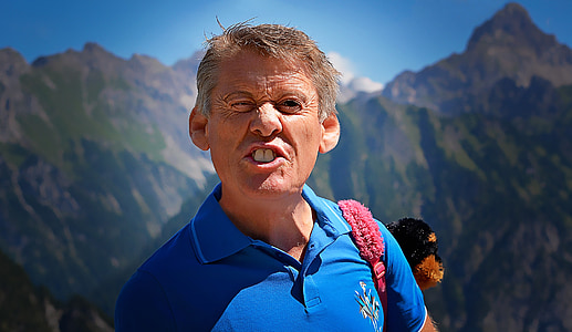 brown mountain behind man under blue sky thumbnail