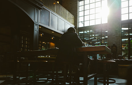 man sitting on chair in facing back in front of table thumbnail