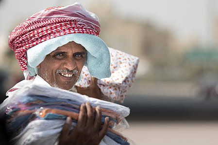 Man Holding Clothing While Smiling thumbnail