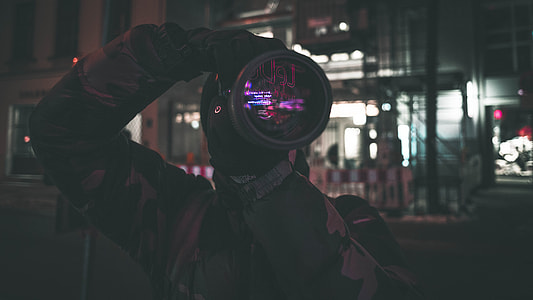 photo of man taking photos of streets during nighttime thumbnail