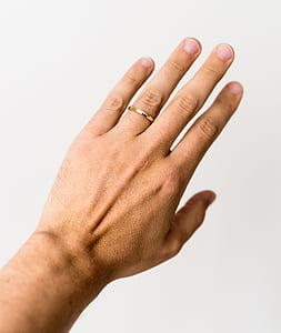 closeup photo of person wearing gold-colored ring thumbnail
