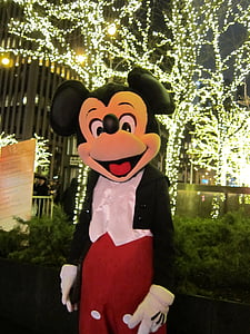 Mickey Mouse mascot in front of LED lighted bare trees thumbnail