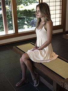woman sitting on brown wooden chair thumbnail