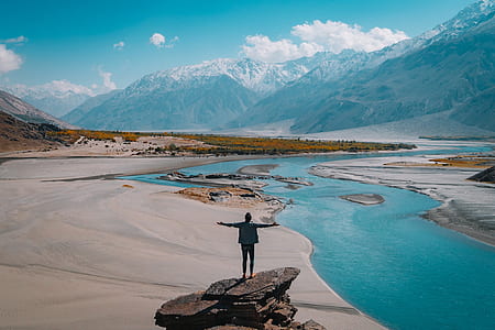 man wearing black suit on the top of the rock thumbnail