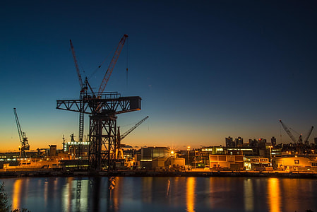 silhouette of crane near body of water at nighttime thumbnail