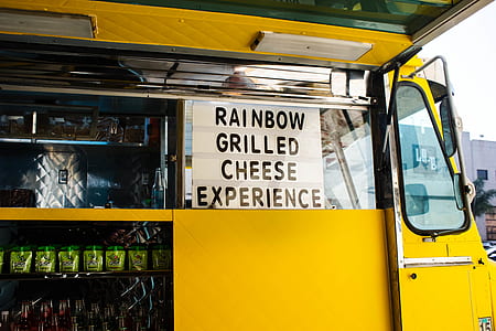 Rainbow grilled cheese experience quote board on window of yellow bus thumbnail