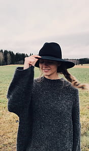 Woman Wearing and Holding Black Summer Hat Outdoor thumbnail