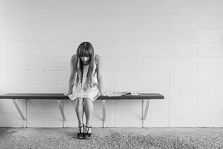 grayscale photography of woman sitting on bench thumbnail