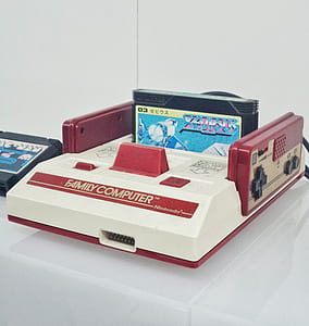red and white Family Computer with game cartridge on table thumbnail