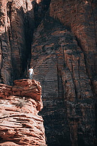 A young caucasian man standing on a layered rock in grand canyon thumbnail