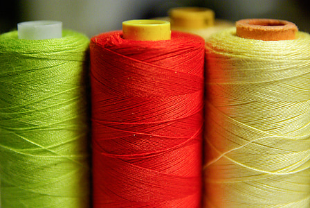 green, red, and yellow threads in shallow focus photography thumbnail