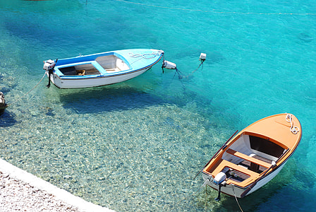 two blue and brown motor boats in blue body of water during daytime thumbnail