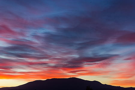 silhouette photography of hill under calm sky thumbnail