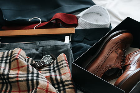 pair of brown dress shoes on box near watch and brown textiles thumbnail