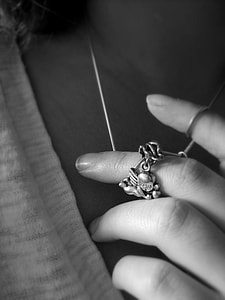 grayscale photo of a woman wearing cherub pendant thumbnail
