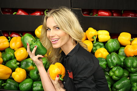 woman wearing black collared shirt and holding green peppers thumbnail