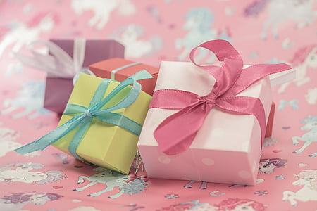 four assorted-color gift boxes on pink surface thumbnail