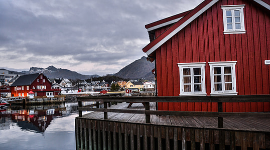 red and white house beside grey calm body of water at daytime thumbnail