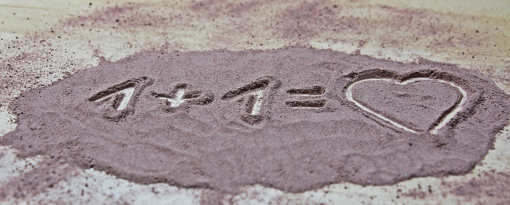 close up photo of 1 + 1 = Heart draw on sand thumbnail