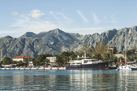 white and black passenger boat beside sailing boat thumbnail