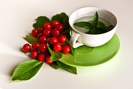 green hear near red fruit and white ceramic cup thumbnail